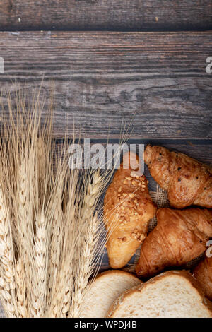 Ansicht von oben Croissants und Brot mit wheatgrass auf dem hölzernen Tisch Stockfoto