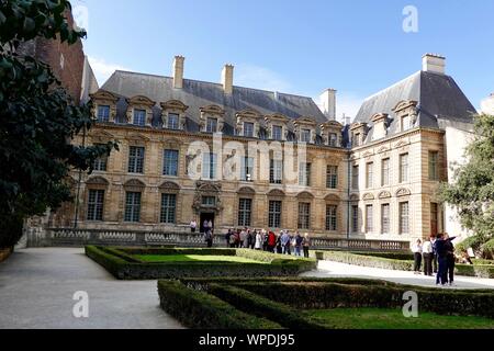 Besucher im Hôtel de Sully Innenhof, ein Patrizierhaus aus dem 17. Jahrhundert im Marais. Jetzt ein französisches Denkmal, Paris, Frankreich. Stockfoto