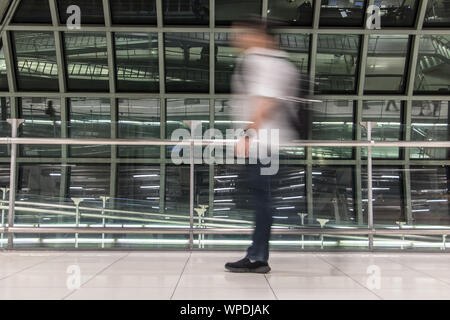 Ein Mann in verschwommene Bewegung am Flughafen in Halle. Abstraktes Bild von Reisenden in der Lobby. Stockfoto