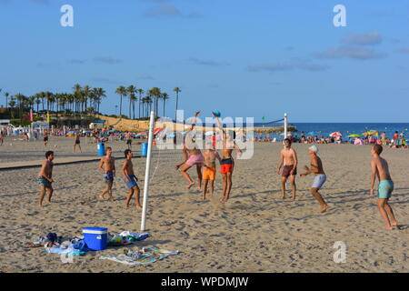 Gruppe junger Männer spielen Beachvolleyball am Strand Arenal in Javea an der Costa Blanca, Spanien. Am späten Nachmittag im Sommer Stockfoto