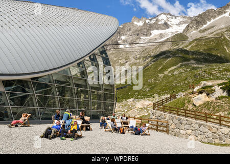 Die Außenseite des Pavillon Seilbahnstation der Skyway Monte Bianco mit Touristen und Wanderer Entspannen und Sonnenbaden an Deck, Stühle, Courmayeur, Italien Stockfoto