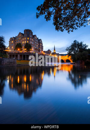 Pulteney Bridge leuchtet in der Dämmerung auf dem Fluss Avon in Bath, Somerset. Stockfoto