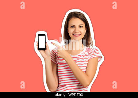 Gerne schöne junge Frau mit langem Haar holding Blank Screen Handy und Zeigefinger. emotionale Mädchen Zeitschrift collage Stil mit trendigen Co Stockfoto