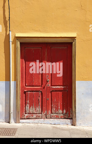Red demaged Holz- Eingang Tür zur Straße in der Altstadt von Santa Cruz, Teneriffa, Kanarische Inseln Stockfoto