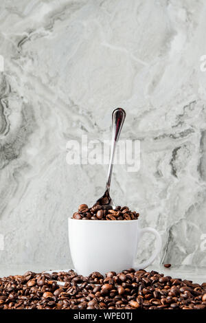 In Tasse schwarzen Kaffee und Kaffeebohnen auf Marmor Hintergrund. Ansicht von oben, Platz für Text Stockfoto
