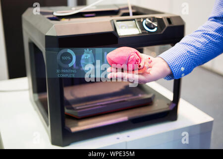 Der Ingenieur zeigt das Herz auf einem 3D-Drucker gedruckt. Stockfoto