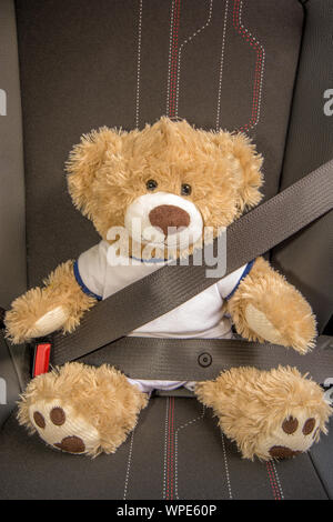 Belted Teddy im Auto symbolisiert das sichere Fahren - vor allem für Kinder Stockfoto