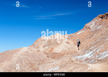 Junge legerer Mann mit Rucksack auf dem Weg zum Mond wie Landschaft des Valle de la Luna (Mondtal), Chile. Reisen Lifestyle wandern Konzept Sommer Vac Stockfoto