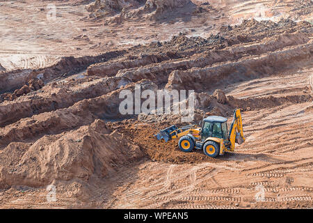 Radlader bagger Maschine arbeiten in Baustelle Radlader im Sandkasten bei Erdbewegungsarbeiten funktioniert. Stockfoto