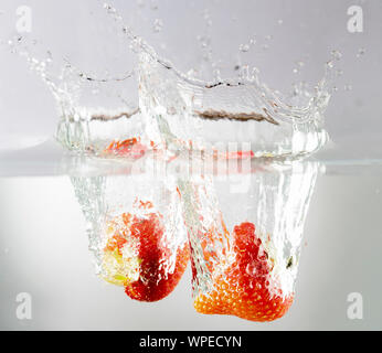 Zwei Erdbeere fiel in Wasser Stockfoto