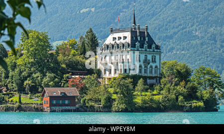 Das schöne Schloss von Iseltwald auf das kristallklare blaue Wasser des Brienzersees im Zentrum der Schweiz. Stockfoto