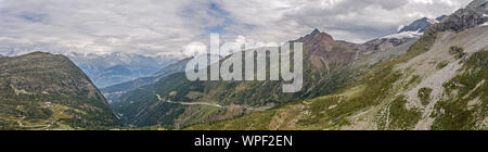 Eine hohe Alpine Mountain Valley und Mountain Road vorbei. Die Straße führt durch hohe Berge und rauhen alpinen felsiges Gelände. Storm clouds Form ov Stockfoto