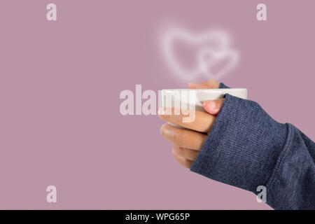 Hand mit einem heißen Kaffee Tasse mit herzförmigen Rauch, Liebe und Valentinstag Konzept mit kopieren. Stockfoto