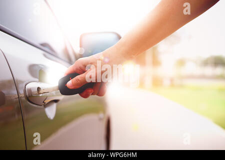 Woman's Hand öffnen, ein Auto mit Schlüssel in den Park. Stockfoto