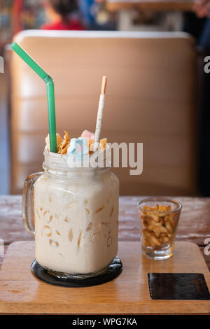 Milchshake mit Marshmallow, süße Kekse, in Glas Marmeladenglas serviert. Stockfoto