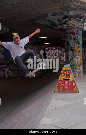 Junge Männer Durchführung von Stunts auf BMX/Skateboards an der South Bank Centre, London. Stockfoto