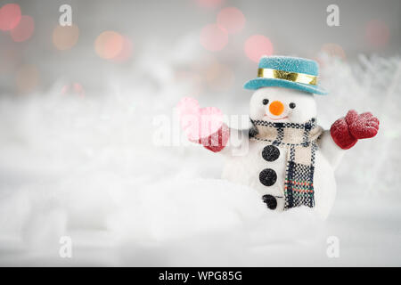 Ein Schneemann- und Mini-Herzkissen auf Bokeh-Hintergrund, mit Kopierraum für die Begrüßung der Saison. Frohe weihnachten oder Happy New Year, AF-Punktauswahl, Klasse Stockfoto