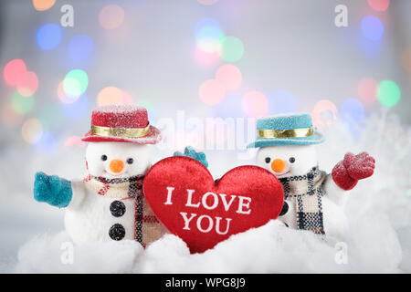 Ein Schneemann- und Mini-Herzkissen auf Bokeh-Hintergrund, mit Kopierraum für die Begrüßung der Saison. Frohe weihnachten oder Happy New Year, AF-Punktauswahl, Klasse Stockfoto