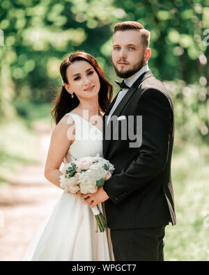 Glückliche Braut und Bräutigam stehen unter der Hochzeit arch Stockfoto