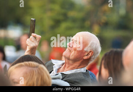 Moskau, Russland - September 8, 2019: Unbekannter älterer Mann Dreharbeiten Szene per Handy bei einem Konzert der Stadt Moskau Tag am 9. September 2019 Stockfoto