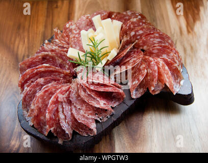 In Scheiben geschnittene Salami und Käse auf dem Holzbrett. Stockfoto