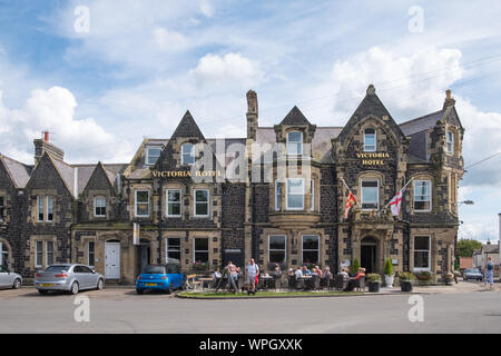 Das Victoria Hotel mit den Menschen draußen im Dorf von bamburgh an der Küste von Northumberland, Großbritannien Stockfoto