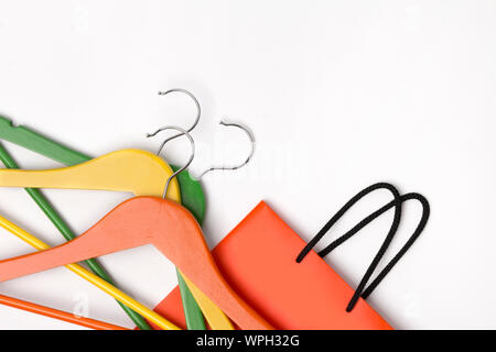 Orange Papier Einkaufstasche mit bunten Kleiderbügel mit weißem Hintergrund. Herbst Sale Konzept. Flach kopieren Raum Stockfoto