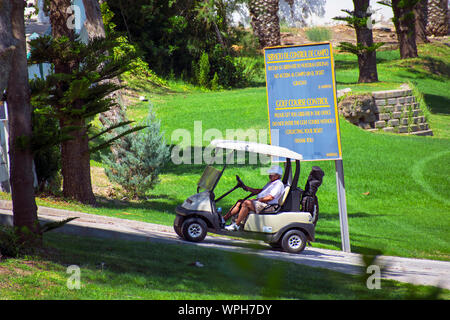 Murcia, Spanien, 25. August 2019: Sportler, ein Golf Cart in einem Spanisch-Kurs. Zwei Männer spielen Golf spielt im Sommer. Grünes Gras, spielt. Stockfoto