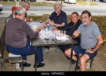 ZRENJANIN, Serbien, SEPTEMBER 05,2019. Eine Gruppe von Senioren meist Rentner Spaß Karten spielen im Freien in den Park. Stockfoto