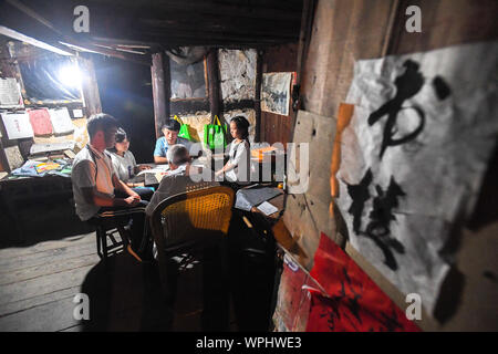 (190909) - CHANGSHA, Sept. 9, 2019 (Xinhua) - Tang Shangjun Tutoren Schüler an seinem Haus in Wuhan Dorf Anhua County in Yiyang City, Central China Provinz Hunan, Sept. 7, 2019. Ein Holzhaus steht allein in den tiefen Bergen durch einen lebhaften grünen Decke von Bäumen bedeckt, nicht nur als Wohnung, sondern auch als ein Klassenzimmer, wo Tang Shangjun Nachhilfe Studenten Seit mehr als 20 Jahren. Tang, einem 92-jährigen ländlichen Lehrer, nachhilfe begonnen, die Kinder durch ihre Eltern mit Migrationshintergrund kostenlos Links in Wuhan Dorf im Jahre 1997, 10 Jahre nachdem er vom Unterrichten in Anhua County zurückgezogen. Stockfoto