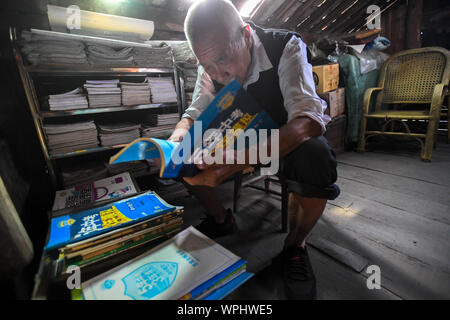 (190909) - CHANGSHA, Sept. 9, 2019 (Xinhua) - Tang Shangjun Art Lehre Materialien, die er zu Hause in Wuhan Dorf Anhua County in Yiyang City gekauft, Chinas Provinz Hunan, Sept. 8, 2019. Ein Holzhaus steht allein in den tiefen Bergen durch einen lebhaften grünen Decke von Bäumen bedeckt, nicht nur als Wohnung, sondern auch als ein Klassenzimmer, wo Tang Shangjun Nachhilfe Studenten Seit mehr als 20 Jahren. Tang, einem 92-jährigen ländlichen Lehrer, nachhilfe begonnen, die Kinder durch ihre Eltern mit Migrationshintergrund kostenlos Links in Wuhan Dorf im Jahre 1997, 10 Jahre nachdem er von der Lehre in den Ruhestand Stockfoto