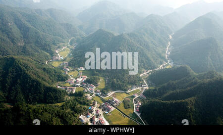 (190909) - CHANGSHA, Sept. 9, 2019 (Xinhua) - Luftaufnahme auf Sept. 8, 2019 zeigt die Landschaft in Wuhan Dorf Anhua County in Yiyang City, Central China Hunan Provinz übernommen. Ein Holzhaus steht allein in den tiefen Bergen durch einen lebhaften grünen Decke von Bäumen bedeckt, nicht nur als Wohnung, sondern auch als ein Klassenzimmer, wo Tang Shangjun Nachhilfe Studenten Seit mehr als 20 Jahren. Tang, einem 92-jährigen ländlichen Lehrer, nachhilfe begonnen, die Kinder durch ihre Eltern mit Migrationshintergrund kostenlos Links in Wuhan Dorf im Jahre 1997, 10 Jahre nachdem er vom Unterrichten in Anhua County zurückgezogen. Stockfoto