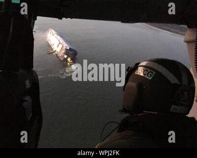 St. Simons Island, Georgia, USA. 08. September 2019. Luftbild von der U.S. Coast Guard Rescue Helicopter zeigt die M/V Golden Ray Frachtschiff, wie es umgekehrt im Wasser liegt nach einem Brand und Kentern in St. Simons Sound Antenne September 8, 2019, St Simons, Georgia, USA. Die 656 Meter lange Fahrzeug Carrier, stark Auflistung nach einem Brand mit 24 Besatzungsmitgliedern an Bord. Quelle: U.S. Coast Guard/Alamy leben Nachrichten Stockfoto