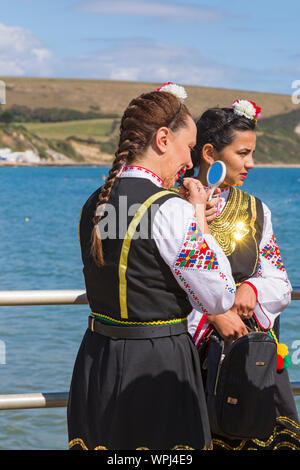 Mitglieder der Zlaten Klas dance Team machen Sie sich bereit, ihre traditionelle bulgarische Tänze in Swanage Folk Festival, Swanage, Dorset UK im September durchführen Stockfoto