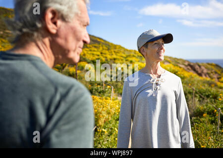 Senior Paar weg schauen beim Stehen auf Berg gegen Himmel während der sonnigen Tag Stockfoto