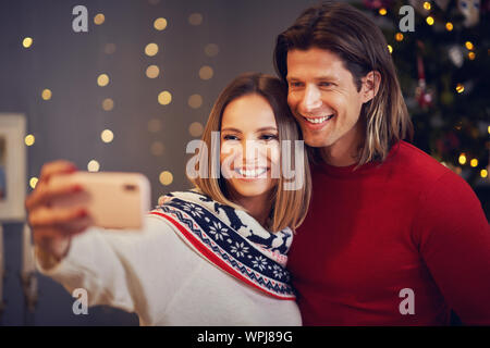 Schönes Paar feiert Weihnachten zu Hause und unter selfie Stockfoto