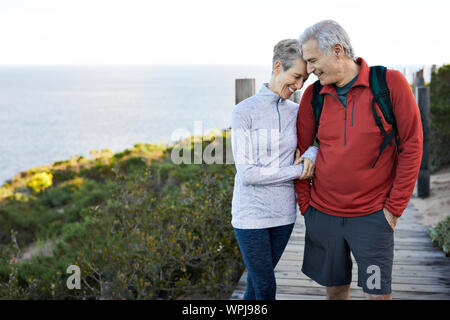 Gerne älteres Paar mit Arm in Arm auf der Promenade von Sea gegen Sky Stockfoto