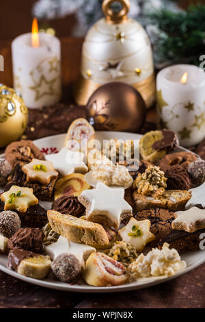 Verschiedene hausgemachte Weihnachtsplätzchen mit Kerzen auf dem Tisch Stockfoto