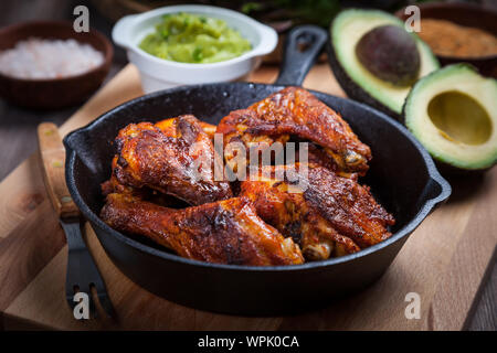 Gegrillte heiße und würzige Chicken Wings mit Gewürzen auf dunklem Hintergrund Stockfoto