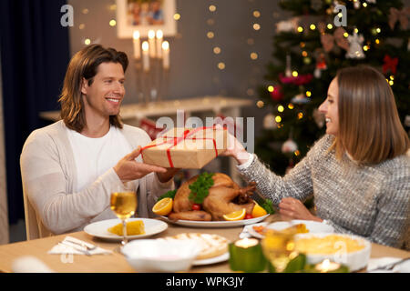 Schönes Paar teilen präsentiert während Weihnachten Abendessen Stockfoto