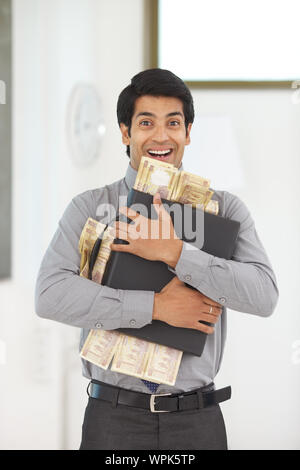 Geschäftsmann mit Banknoten und Aktenkoffer Stockfoto