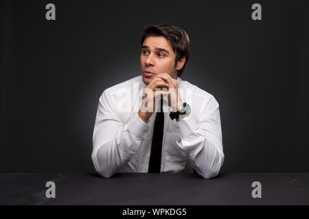 Geschäftsmann sitzt mit Händen halten Stockfoto