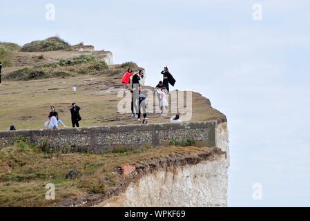 Junge koreanische Touristen fotografieren stehen am Rand der Kreidefelsen am Birling Gap Eastbourne East Sussex England Großbritannien Stockfoto