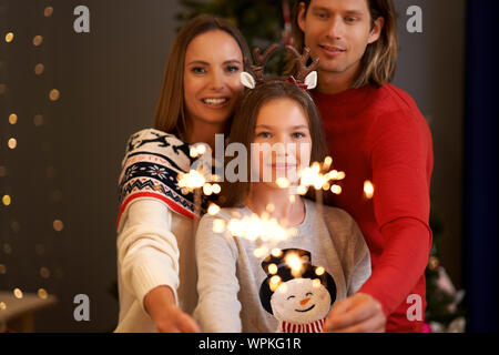 Schöne Familie feiern Weihnachten und Holding Wunderkerzen Stockfoto