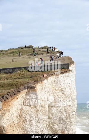 Junge koreanische Touristen fotografieren stehen am Rand der Kreidefelsen am Birling Gap Eastbourne East Sussex England Großbritannien Stockfoto