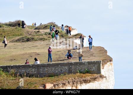 Junge koreanische Touristen fotografieren stehen am Rand der Kreidefelsen am Birling Gap Eastbourne East Sussex England Großbritannien Stockfoto