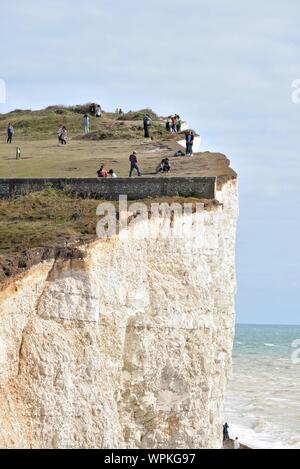 Junge koreanische Touristen fotografieren stehen am Rand der Kreidefelsen am Birling Gap Eastbourne East Sussex England Großbritannien Stockfoto