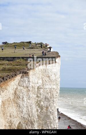 Junge koreanische Touristen fotografieren stehen am Rand der Kreidefelsen am Birling Gap Eastbourne East Sussex England Großbritannien Stockfoto