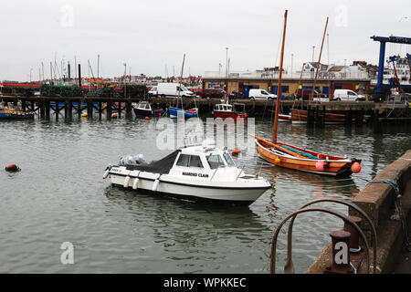 Boote in Bridlington Hafen mit Reflexionen enthalten. Der eine ist ein Yorkshire coble Stockfoto