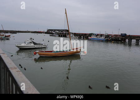 Boote in Bridlington Hafen mit Reflexionen enthalten. Der eine ist ein Yorkshire coble Stockfoto